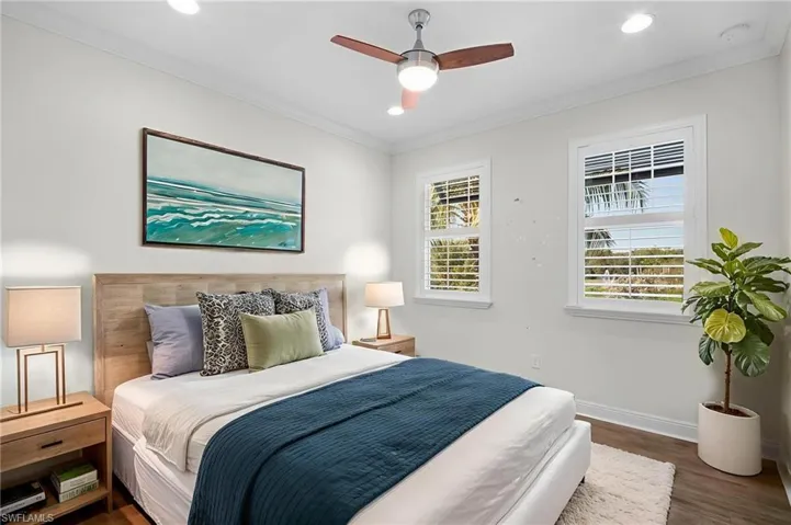 Bedroom with dark wood-type flooring, a ceiling fan, ornamental molding, and recessed lighting