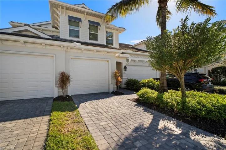 View of front of house featuring stucco siding, decorative driveway, and a garage