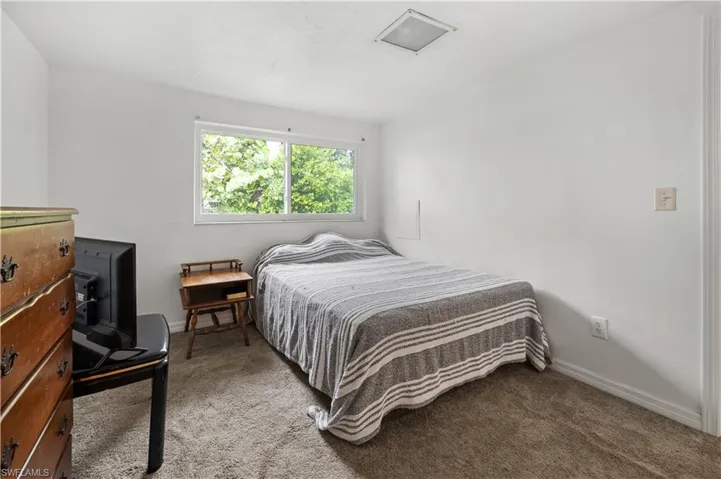 Bedroom with light colored carpet in apartment