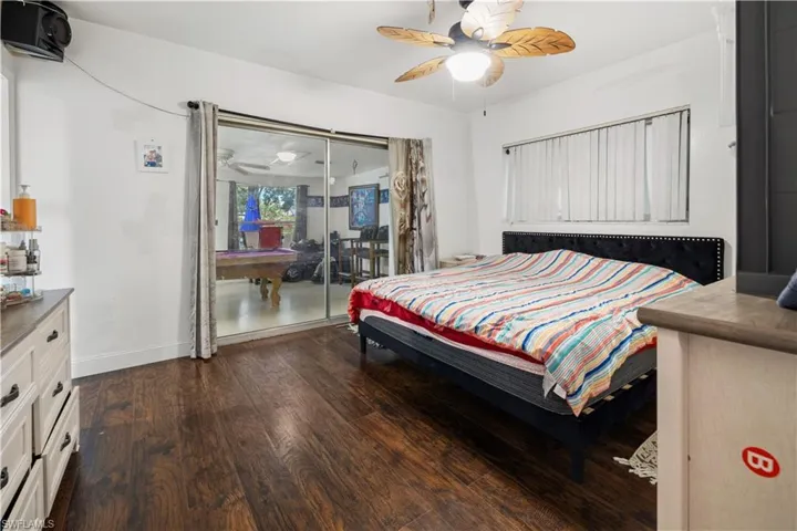 Bedroom featuring dark wood-type flooring, ceiling fan, and access to outside