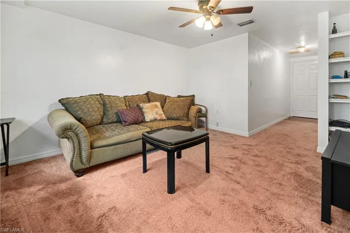 Living room featuring built in features, ceiling fan, and carpet floors in apartment