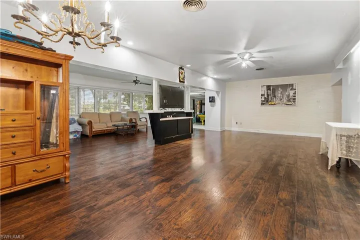 Living room featuring dark hardwood / wood-style floors and ceiling fan with notable chandelier