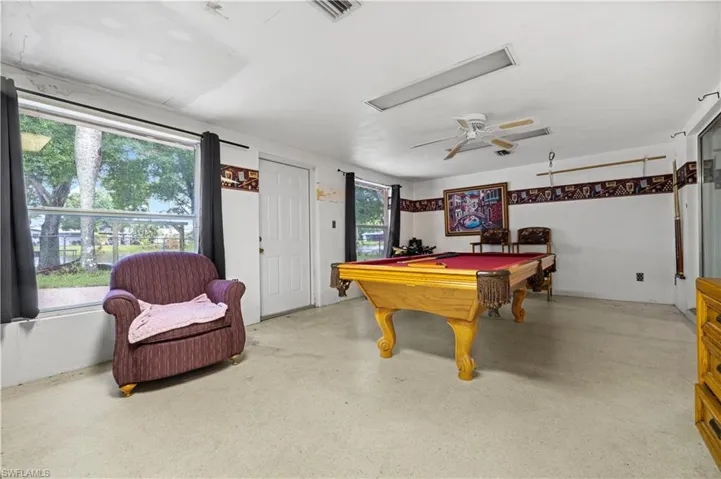 Game room ( enclosed patio) with billiards and ceiling fan