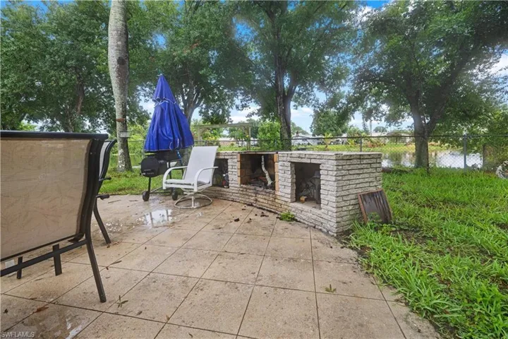 View of patio with an outdoor brick fireplace