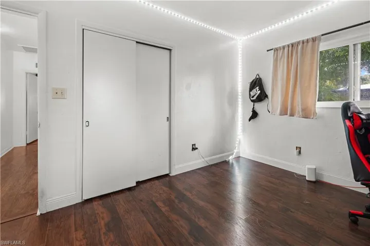 Unfurnished bedroom with dark wood-type flooring and a closet