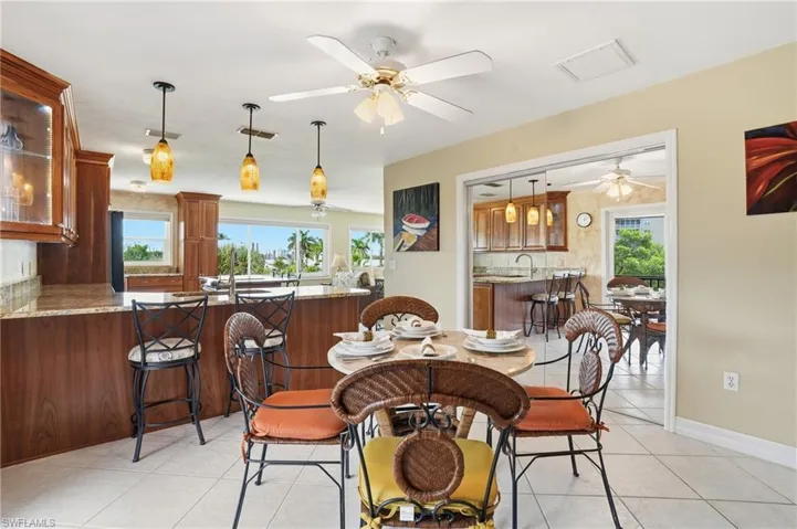 Dining space with light tile patterned flooring and ceiling fan - Virtually Edited Image