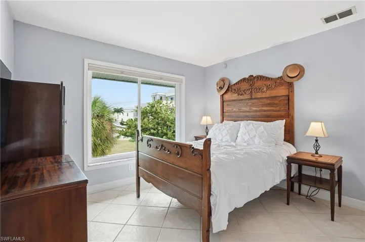 Bedroom featuring baseboards and light tile patterned floors - Virtually Edited Image
