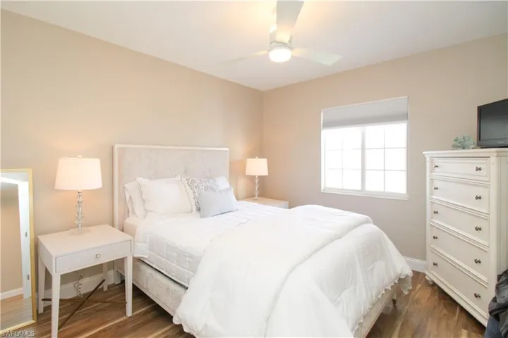 Bedroom with ceiling fan and dark hardwood / wood-style floors