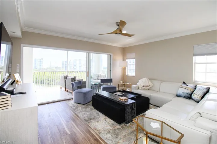 Living room with ornamental molding, hardwood / wood-style floors, and ceiling fan