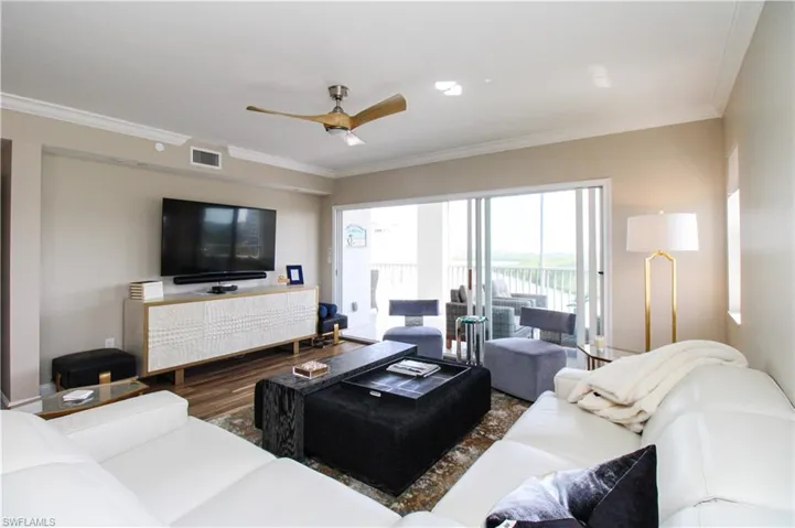 Living room with crown molding, hardwood / wood-style floors, and ceiling fan