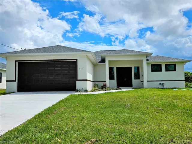 View of front facade with a front lawn and a garage
