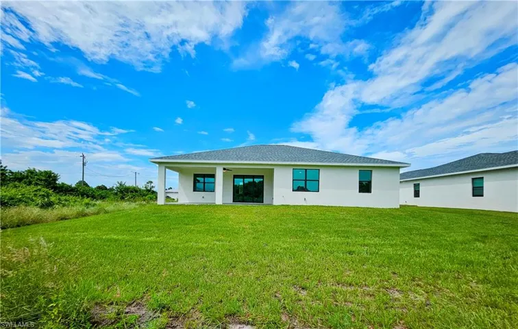 Back of property featuring a yard