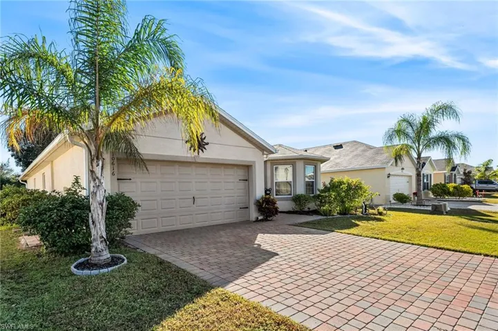 Ranch-style house featuring a garage and a front lawn