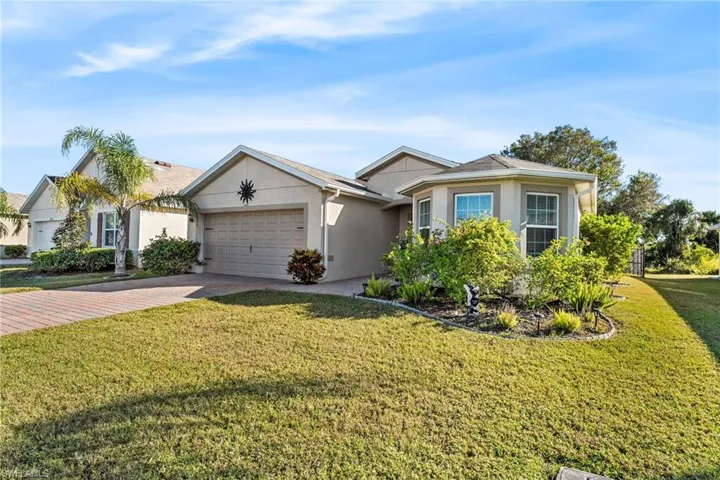 Ranch-style home featuring a front yard and a garage