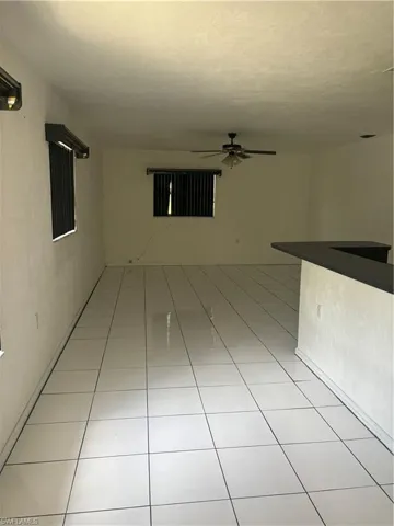 Spare room featuring ceiling fan and light tile patterned floors