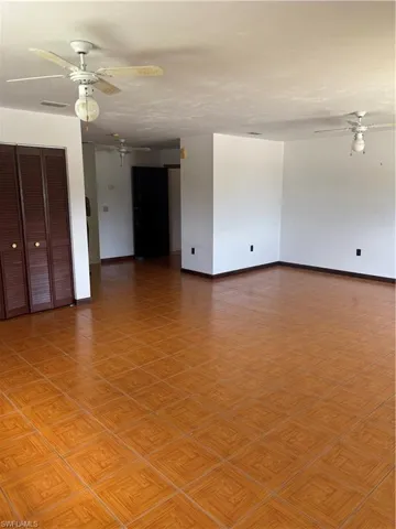 Empty room with ceiling fan and light parquet floors