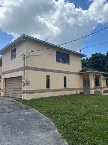 View of side of home with a yard and a garage