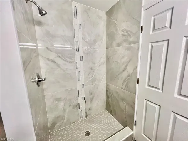 Primary Bathroom featuring a newly tiled shower.