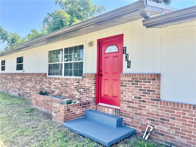 Doorway to property featuring brick siding