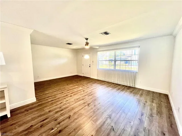 Living room featuring crown molding, LUXURY VINYL PLANK FLOORS.