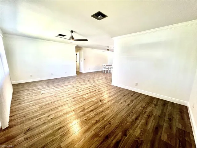 Living room featuring crown molding, LUXURY VINYL PLANK FLOORS.