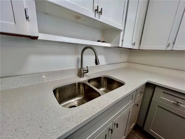 Kitchen featuring open shelves, a sink, white cabinetry, and light QUARTZ counters