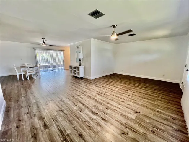 Living room featuring crown molding, LUXURY VINYL PLANK FLOORS.