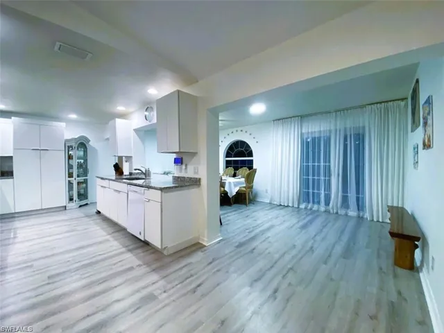 Kitchen featuring white cabinets, light wood-style flooring, white dishwasher, recessed lighting, and modern cabinets