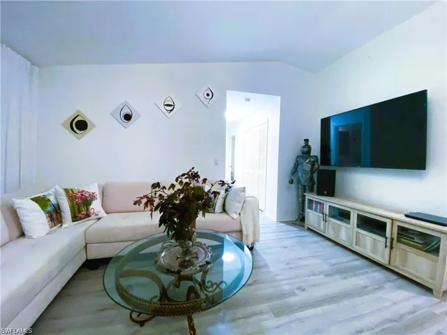 Living room featuring vaulted ceiling and light wood finished floors