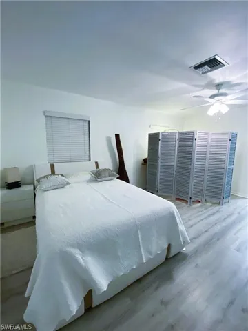 Bedroom featuring wood finished floors, ceiling fan, and multiple closets