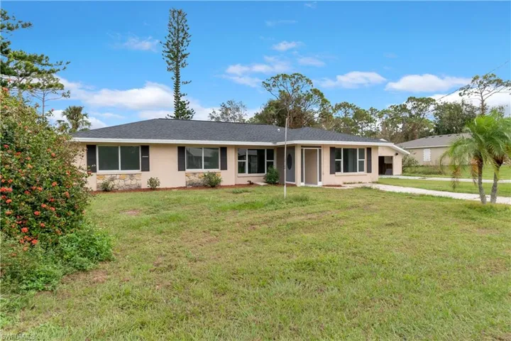 Ranch-style home featuring a front lawn