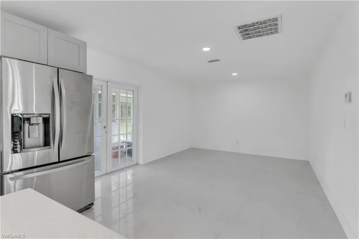 Kitchen with stainless steel fridge and white cabinets