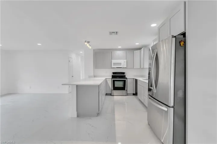 Kitchen featuring gray cabinets, kitchen peninsula, and stainless steel appliances