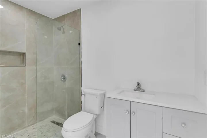 Bathroom with vanity, toilet, and an enclosed shower