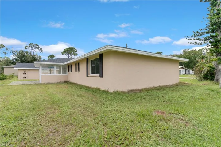 Rear view of property with a yard