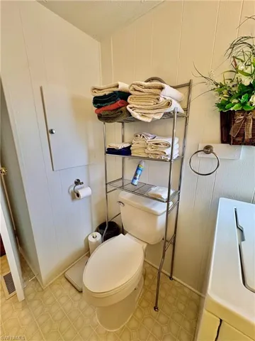 Bathroom featuring a decorative wall, vanity, and washer / dryer