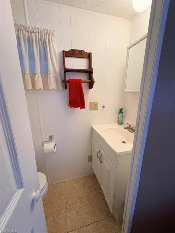 Bathroom with vanity, a decorative wall, and a textured ceiling