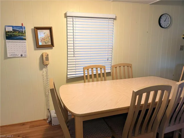 Dining area featuring wood finished floors and wooden walls