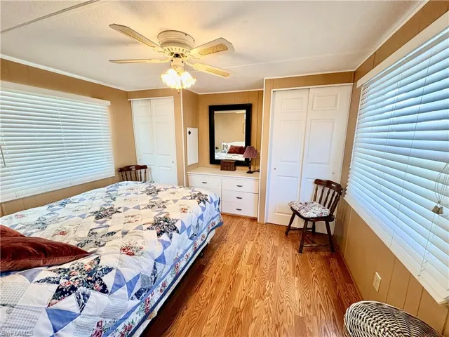 Bedroom featuring multiple closets, light wood-type flooring, and multiple windows