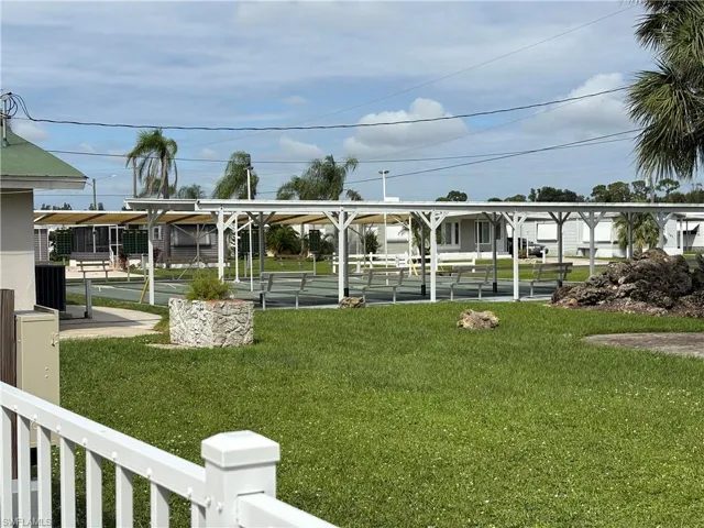 Surrounding community with shuffleboard and a yard