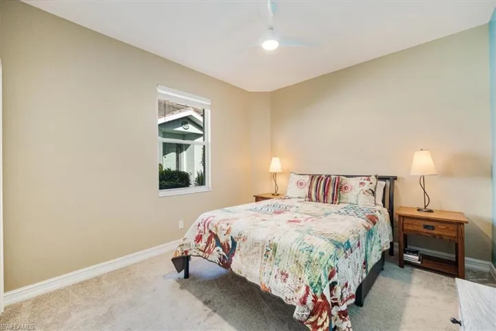 Front Bedroom with ceiling fan, light colored carpet and light and bright windows
