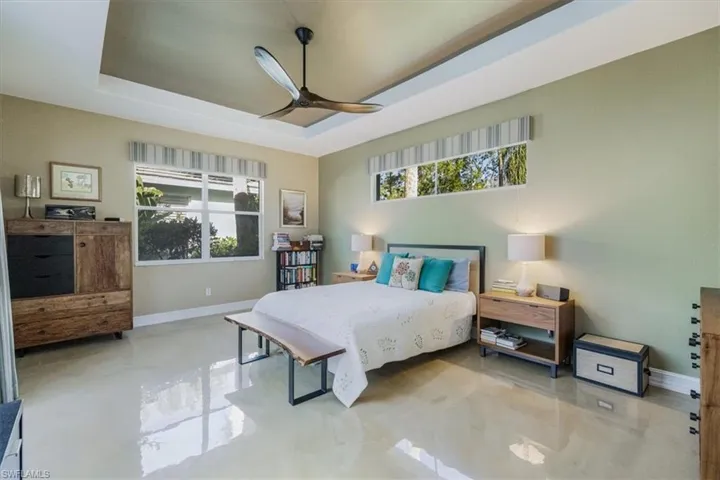 Master Bedroom with a tray ceiling, lots of natural light, sliding door to lanai and private pool and beautiful concrete painted floors