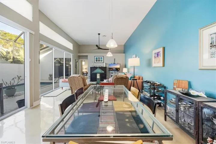 Formal dining area with concrete painted flooring opening to great room adjacent to screened lanai with private pool