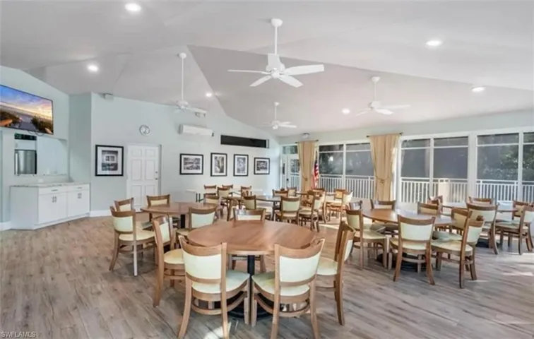Dining area with light wood finished floors, recessed lighting, high vaulted ceiling, and kitchen with community library
