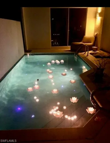 View of private pool at night with candles