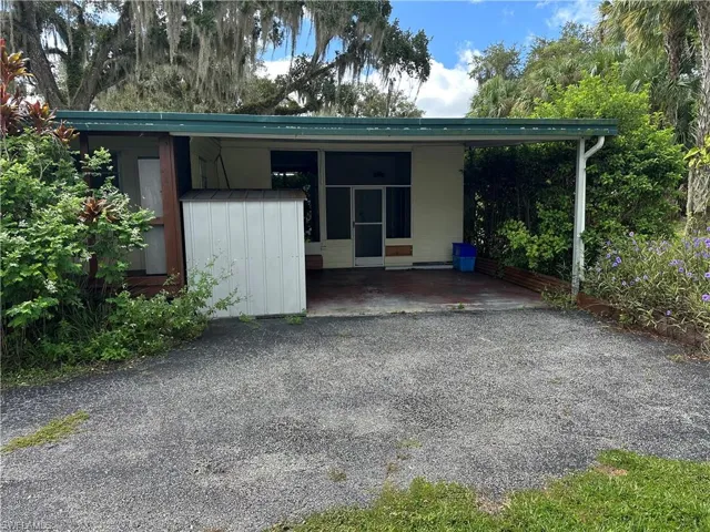 View of front facade with an attached carport and a patio area