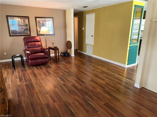 Sitting room with dark wood-style floors and baseboards