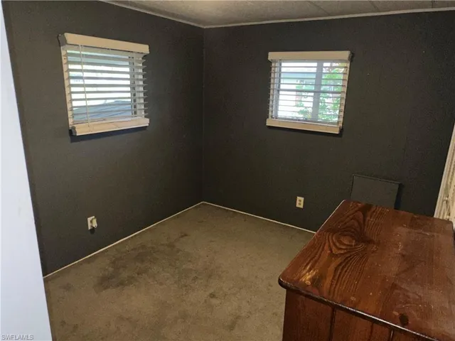 Unfurnished office featuring carpet flooring and ornamental molding