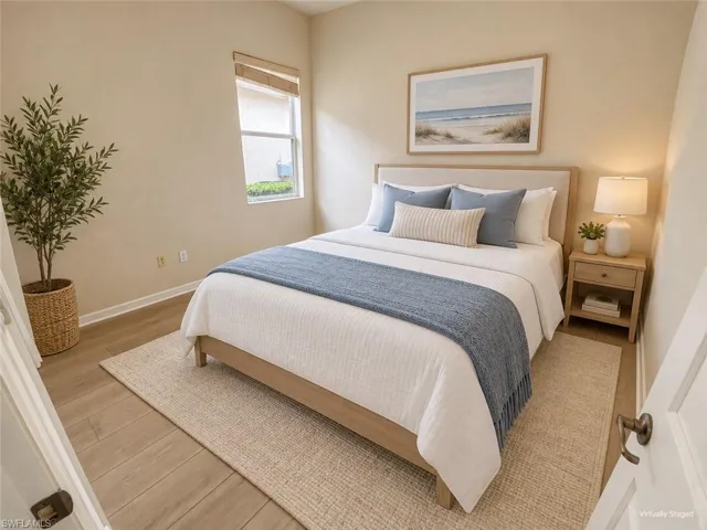 Light wood-finish flooring, single window with a woven shade, and neutral-toned walls