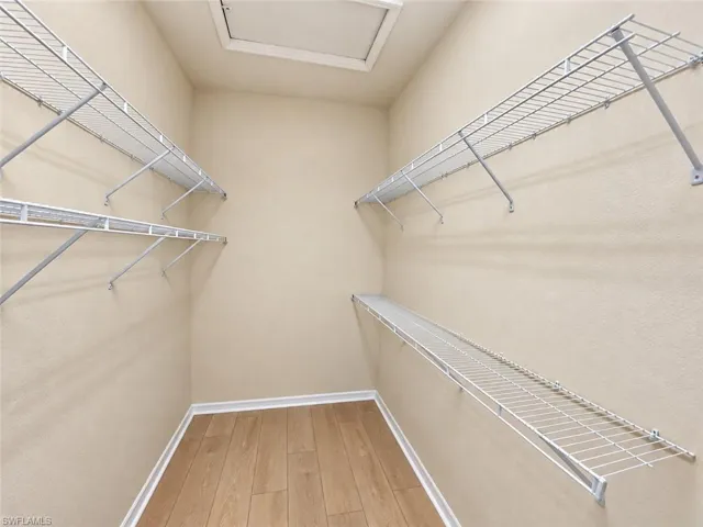 Walk-in closet with wire shelving and wood-finish flooring